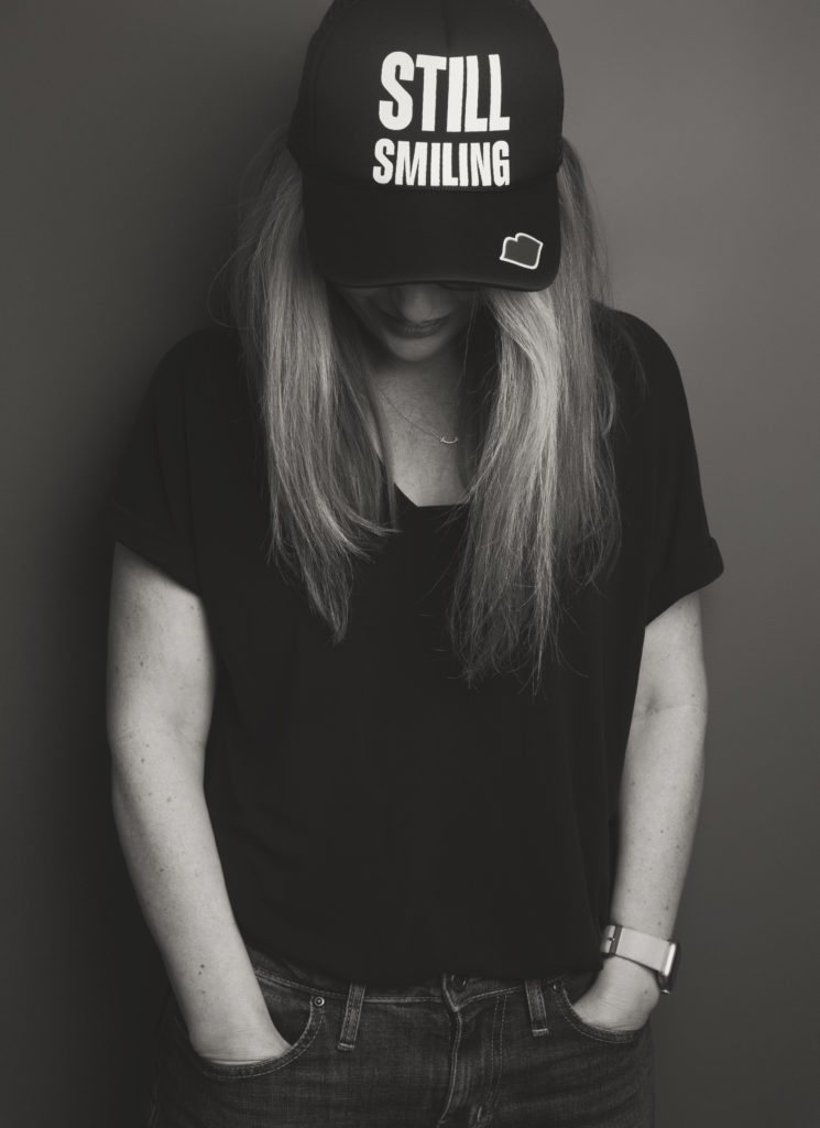 Ruth Limkin in a cap that reads Still Smiling